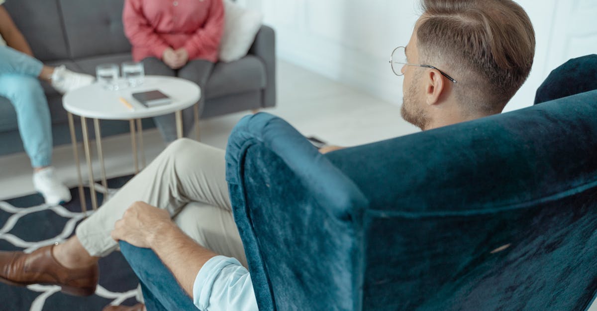 A man having a counseling session with a therapist in a modern office setting.